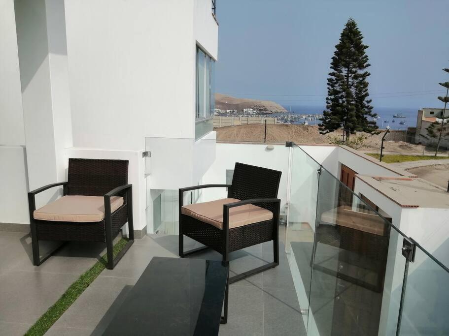 普库萨纳Desestresate en la tranquilidad de la linda bahia的两把椅子坐在大楼的阳台上