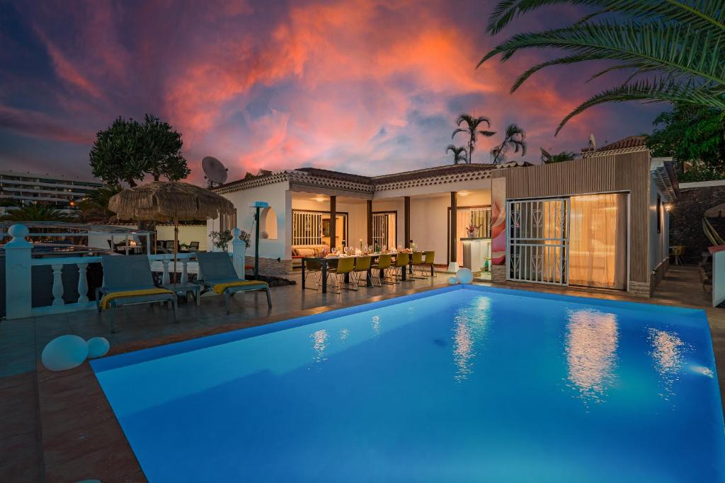 洛斯克里斯蒂亚诺斯Villa 4bed private pool en Los Cristianos的一座游泳池,位于一座享有日落美景的房屋前
