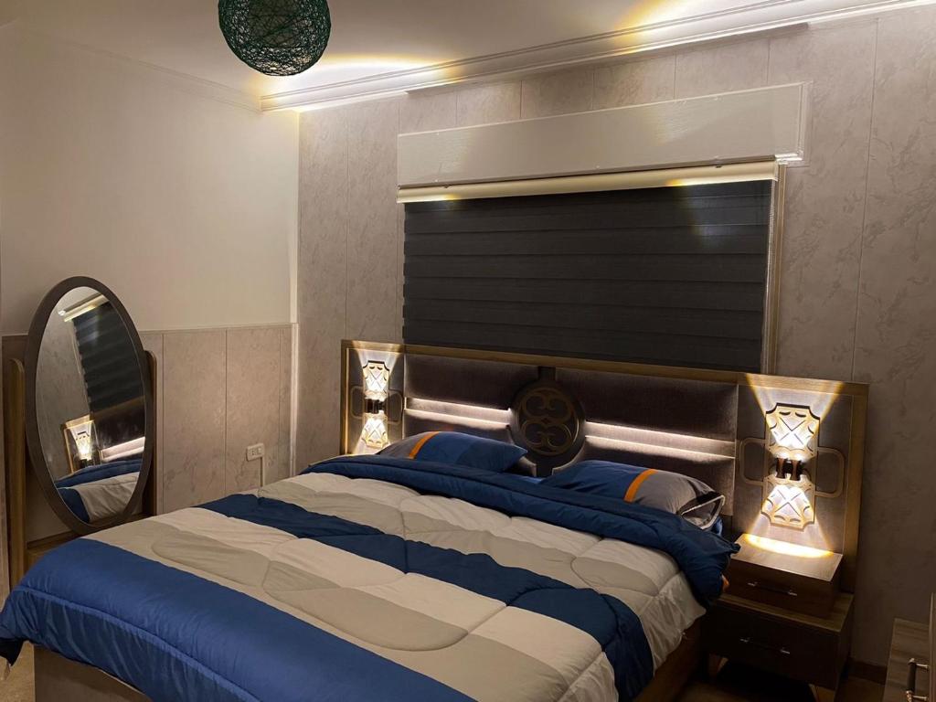 伊尔比德شركة مسايا لشقق المفروشة的一间卧室配有一张带镜子的大床