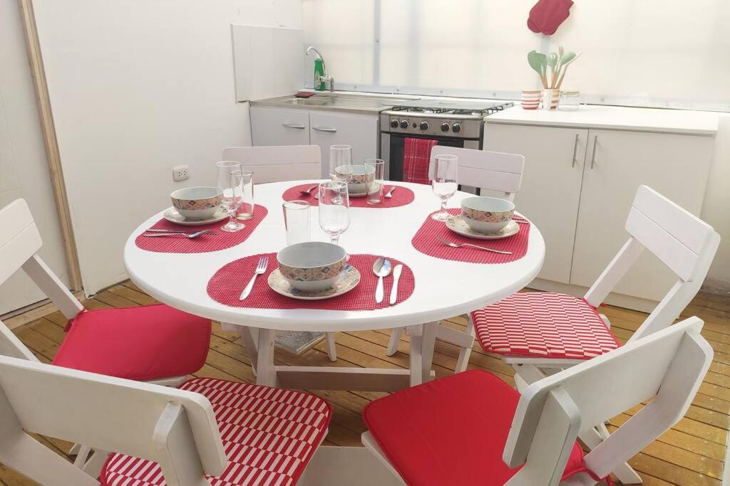 库斯科Departamento en Centro histórico de Cusco (PASEO LOS HEROES)的厨房里配有红色餐巾和椅子的白色桌子