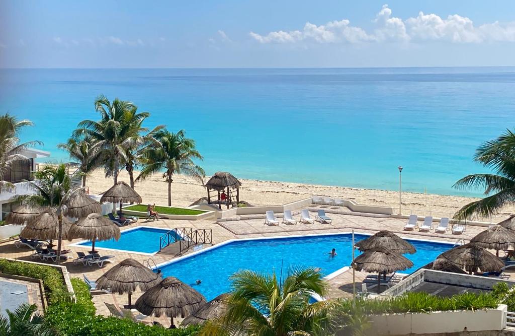 坎昆Beach & Ocean Front Apartments Brisas Cancun Zona Hotelera的一个带游泳池和海滩的度假胜地