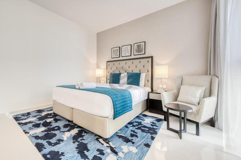 迪拜One Bed Apartment in Dubai - Dubai South - Damac Celestia的一间卧室配有一张大床和一把椅子