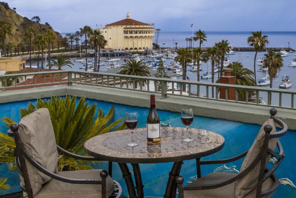 阿瓦隆卡特琳娜岛阿瓦隆酒店的阳台上的桌子和两杯葡萄酒