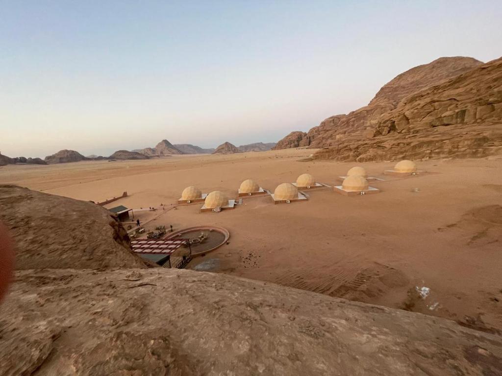 瓦迪拉姆Wadi Rum Aviva camp的一群在沙漠中的圆顶,有山