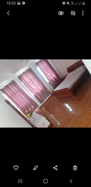 TarrafalResidencial/ Pensão Natur的一张房间的照片,房间有一个窗户,有粉红色的窗帘