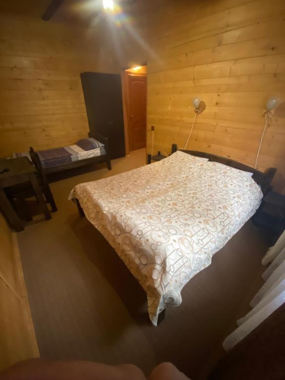 亚布卢尼齐亚Highland的木制客房内的一间卧室,配有一张床