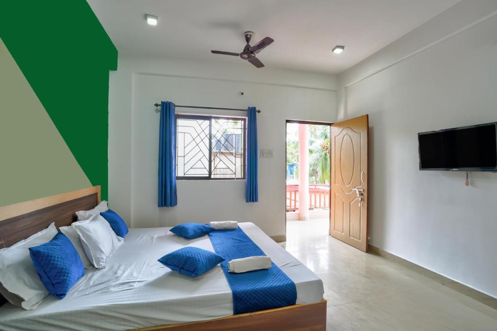 卡兰古特Rooms Beach Bunch House Goa的一间卧室配有一张带蓝色枕头的大床