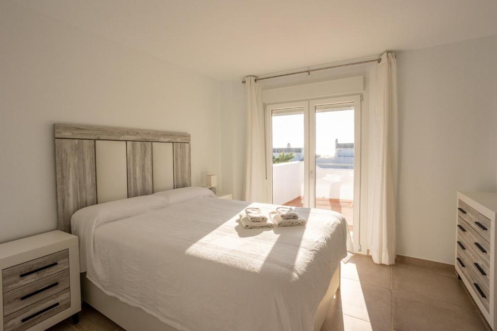 萨阿拉德洛斯阿图内斯Playa Blanca Zahara的白色的卧室设有床和窗户
