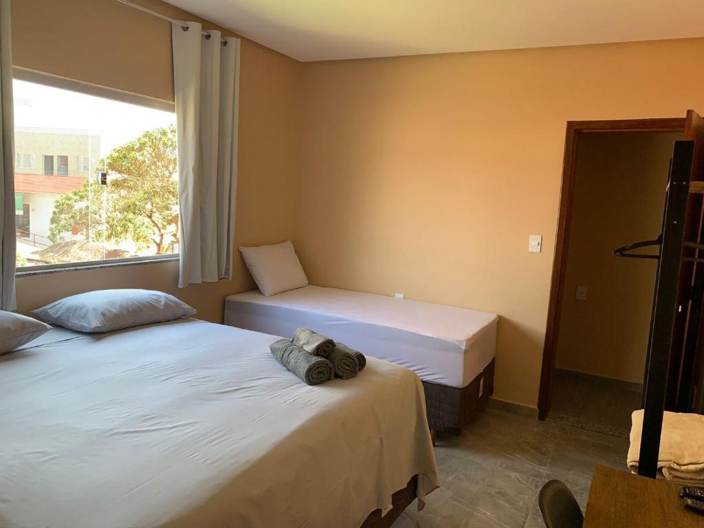伊比科阿拉Pousada Licuri Ibicoara的一间卧室设有两张床和窗户。