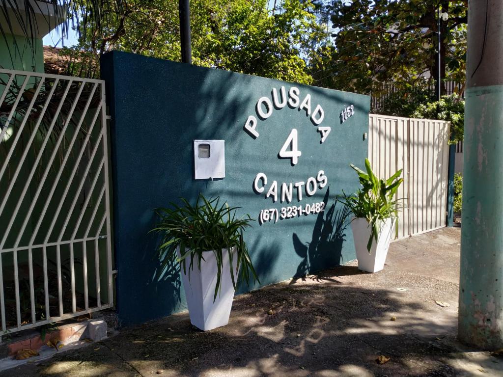 科伦巴Pousada 4 cantos的一面蓝色的墙,围栏旁边有两个盆栽植物