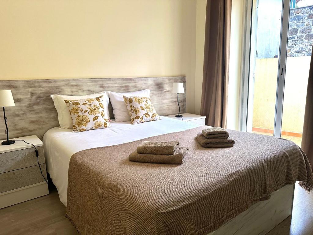 圣维森特Casa das Ginjas的一间卧室配有带毛巾的床