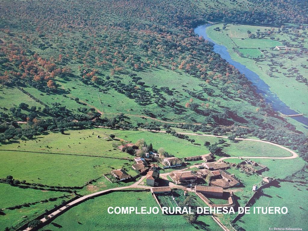 Complejo Rural Dehesa de Ituero的河流旁村庄的空中景观