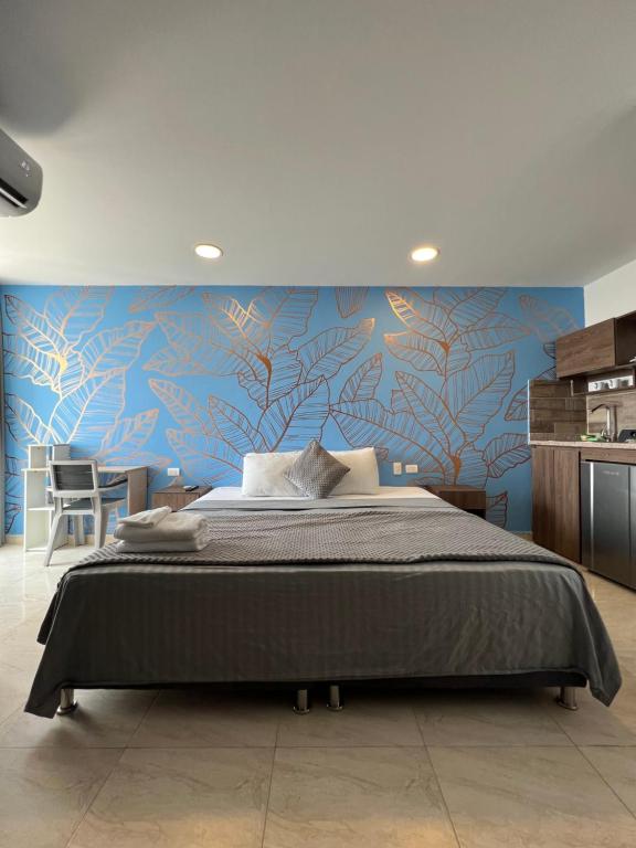 卡塔赫纳Bahia 79 Apartasuites Cerca al Centro的一间卧室设有一张蓝色墙壁的大床
