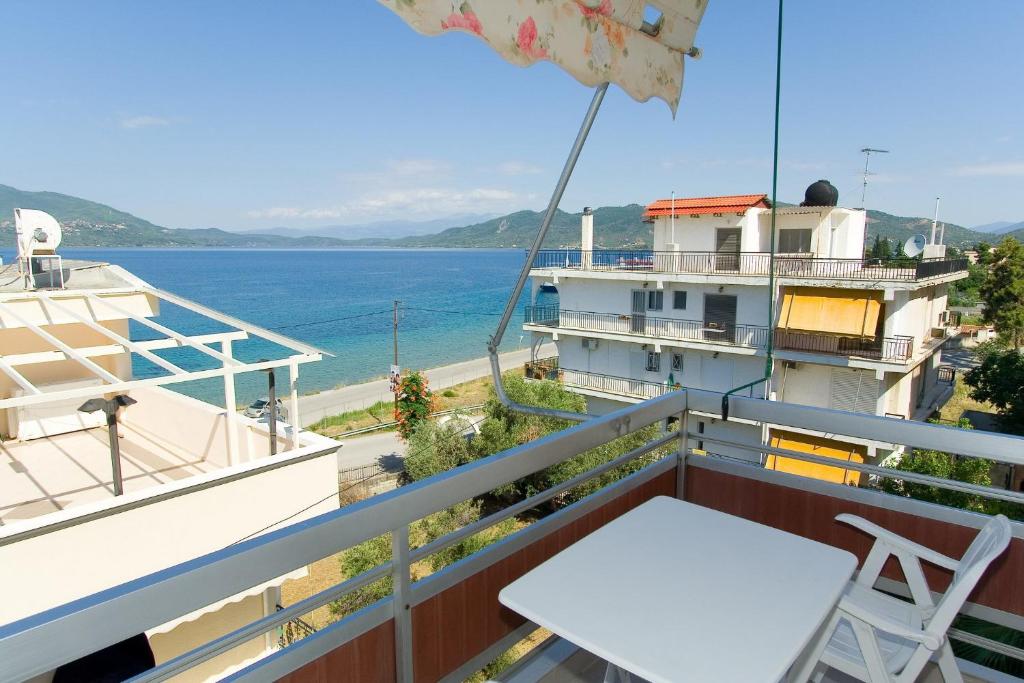 卢特拉艾季普苏Valkaniotis Apartments的一个带桌椅的海景阳台