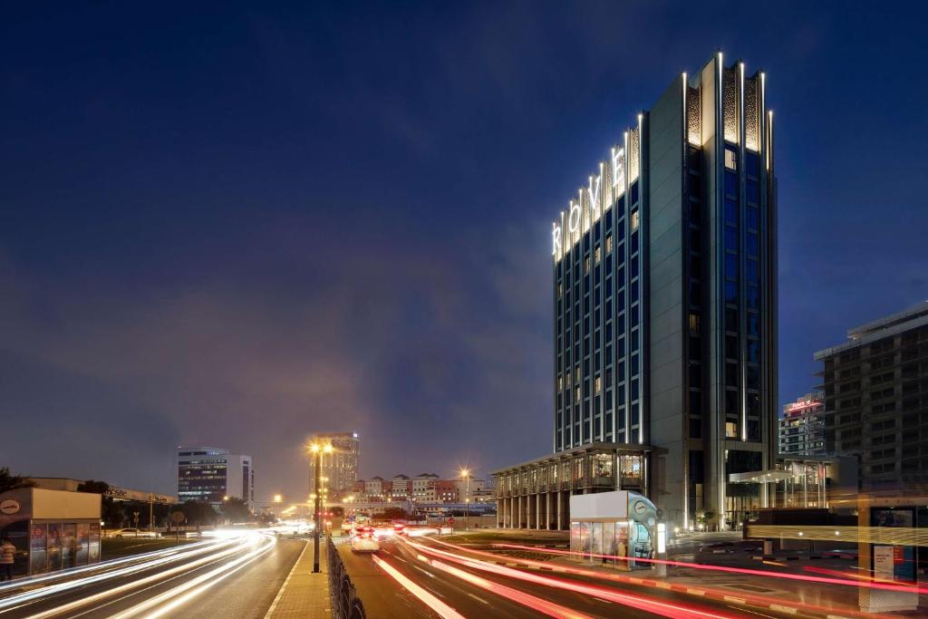 迪拜Rove Healthcare City - Bur Dubai的夜幕降临的城市街道上一座高楼