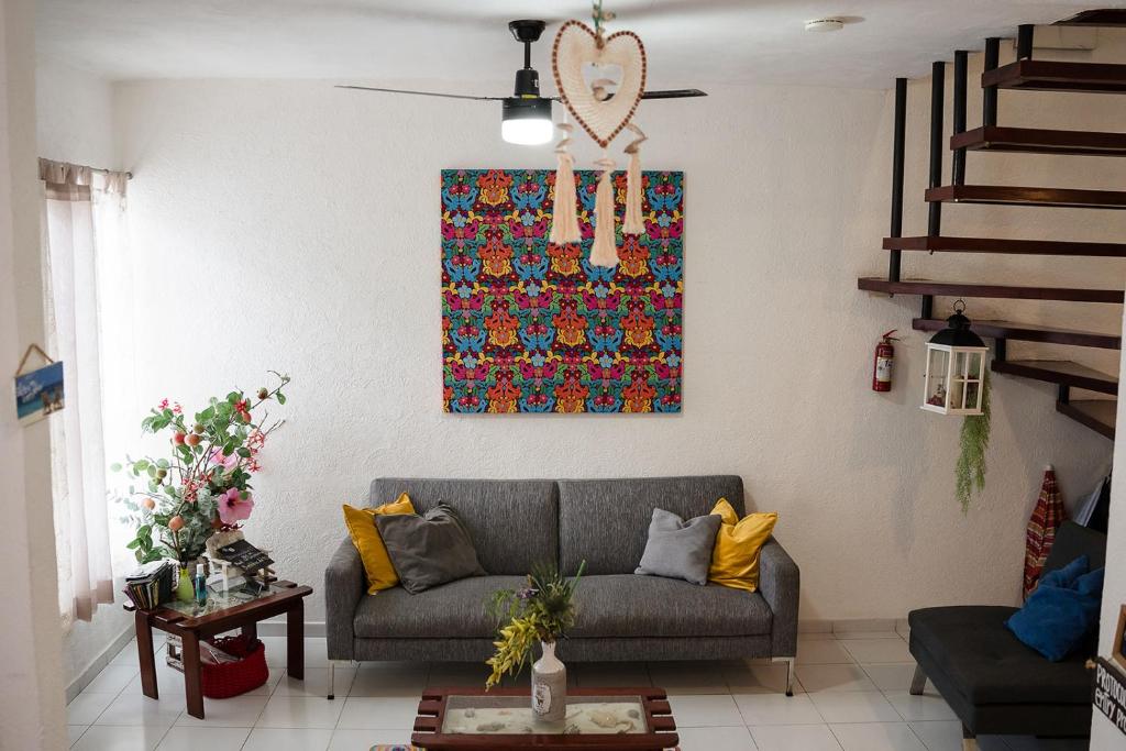 坎昆Casa Aurora的客厅配有沙发和墙上的绘画