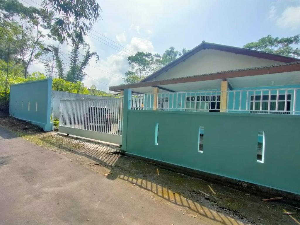 SoprayanHutama Kaliurang Guest House的前面有栅栏的蓝色房子