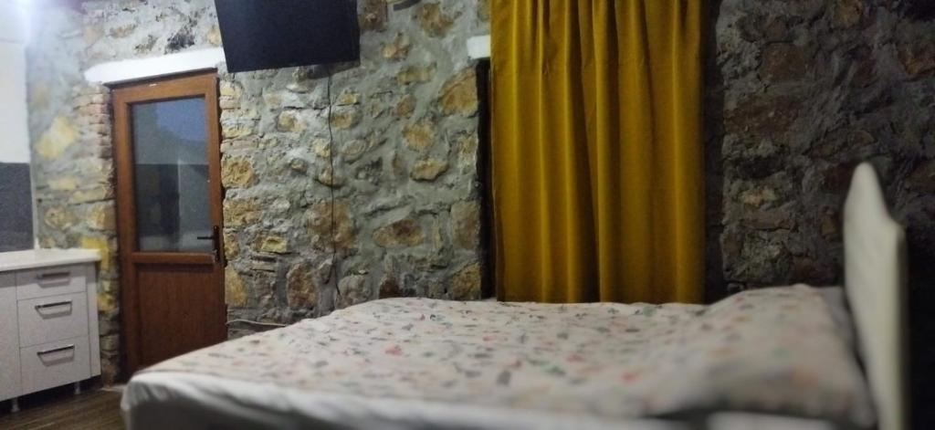 DağpınarSu camping的一间卧室设有一张床和石墙