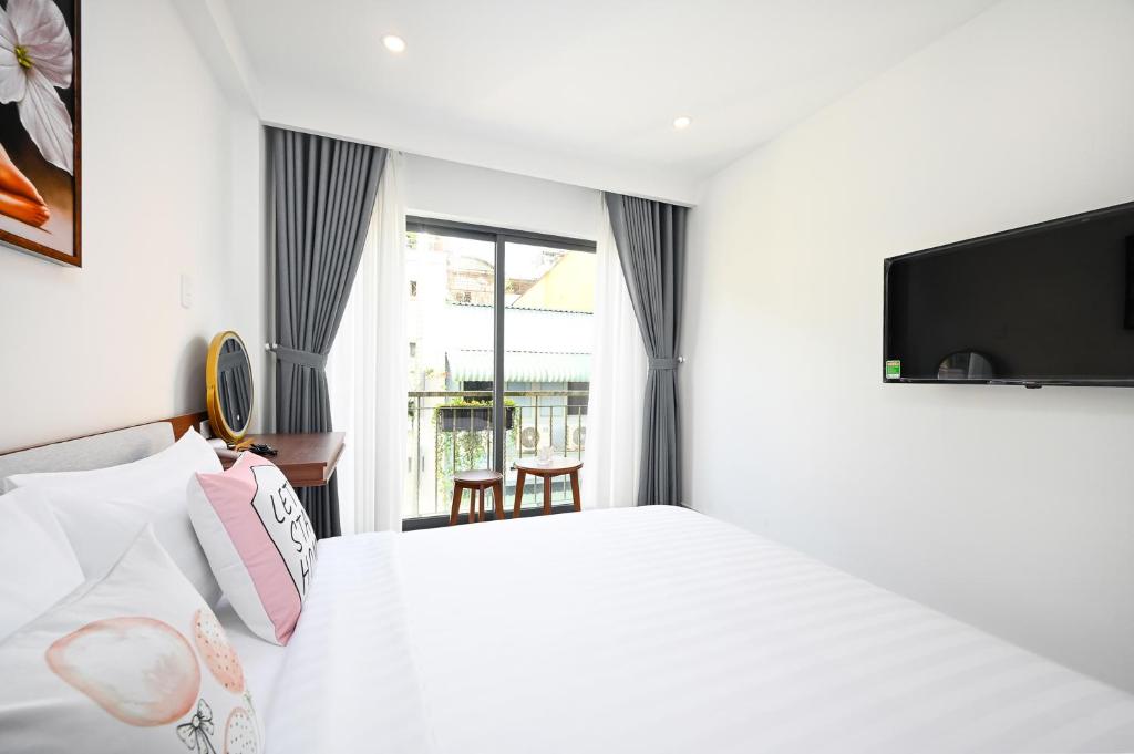 胡志明市Saigon Hotel & Apartment的一间酒店客房,配有一张床和一台电视