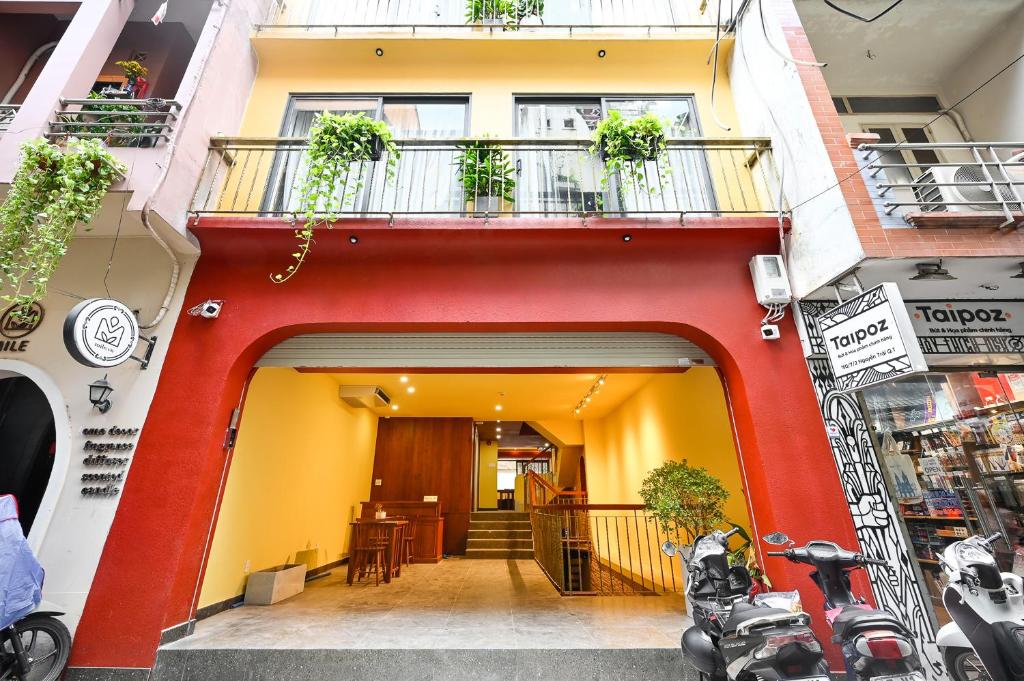 胡志明市Saigon Hotel & Apartment的红色和黄色的建筑,设有阳台和桌子