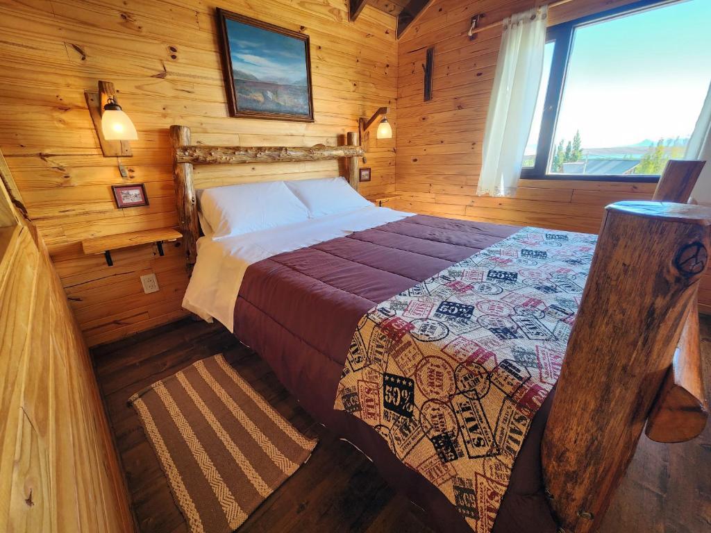 埃尔卡拉法特艾乐琛山林小屋的小木屋内一间卧室,配有一张床