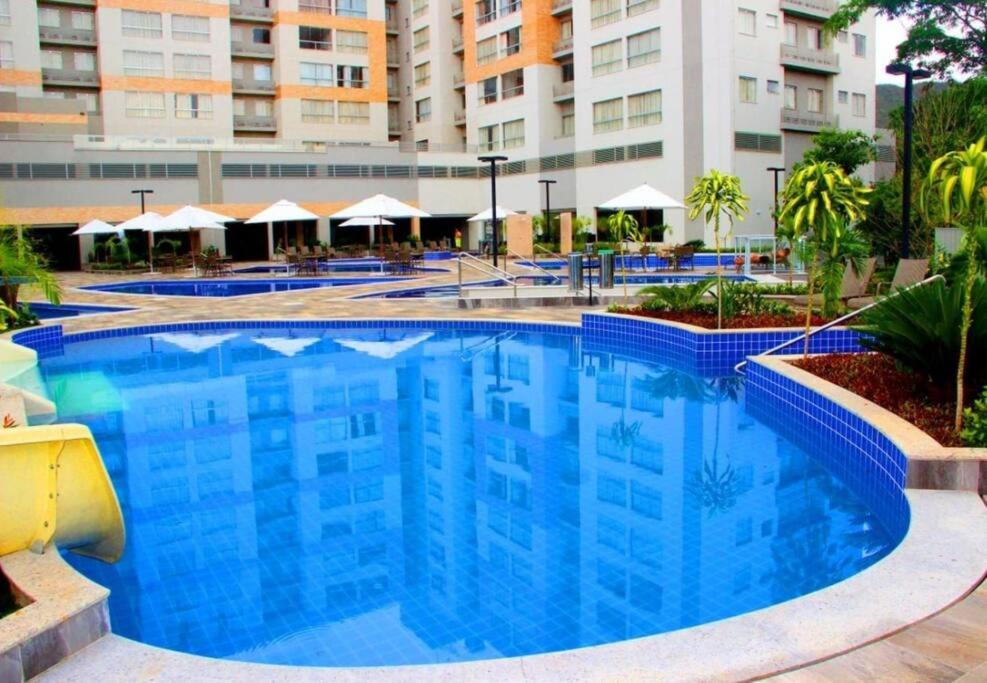 热河市Rio Quente - Flat 3113 Park Veredas - Acesso ao Rio, ao lado Hot park的大楼前的大型蓝色游泳池