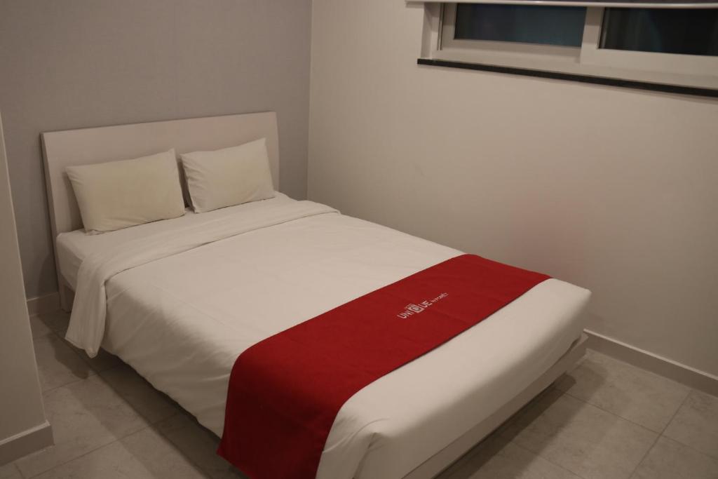 首尔Hotel Unique by Foret的床上有红白毯子