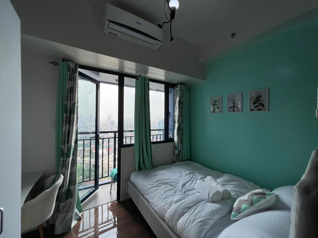 马尼拉Cozy Condo Apartment in Makati / Manila with mall, restaurants, groceries, pool, netflix, disney+ and more的一间卧室设有一张床和一个大窗户