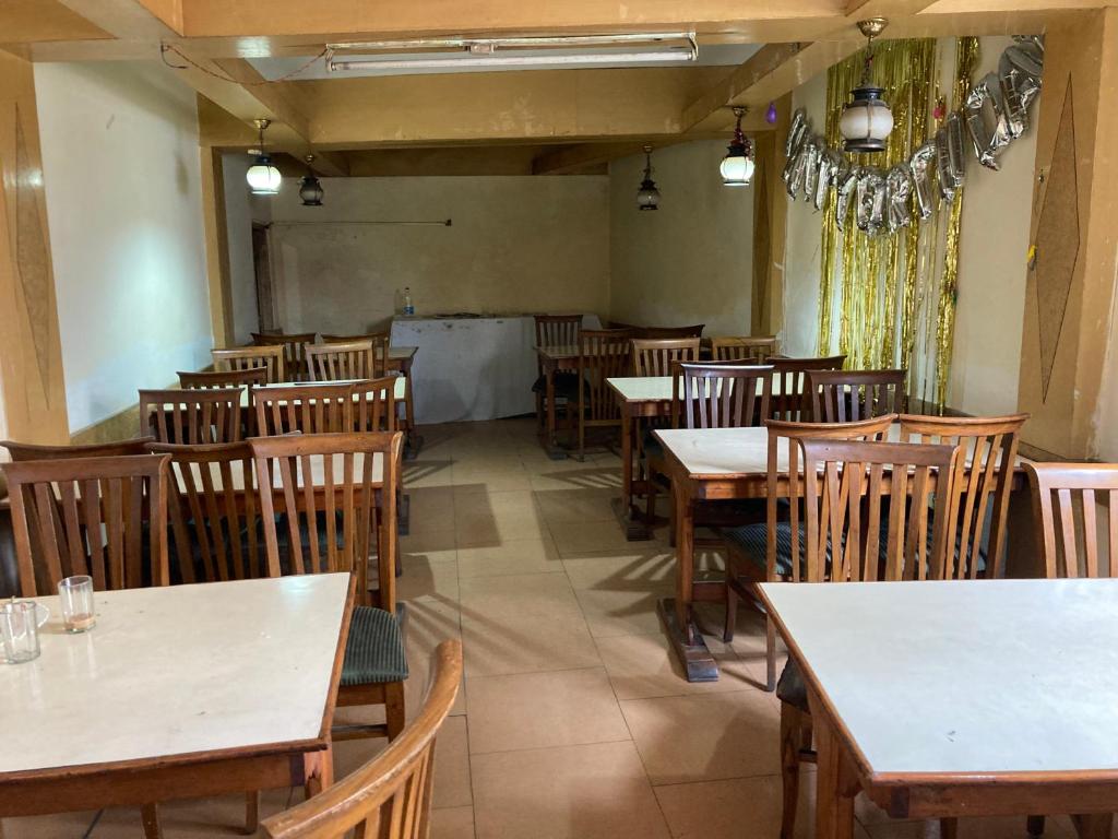 钱德加尔Sandhu Farm House的用餐室配有桌子和木椅