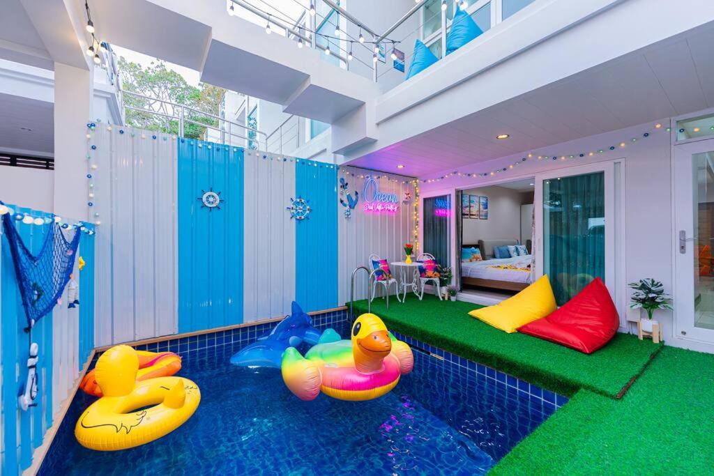 邦萨雷Ocean Pool Villa Pattaya的一间房间,地板上设有一个游泳池,上面有两个橡胶鸭