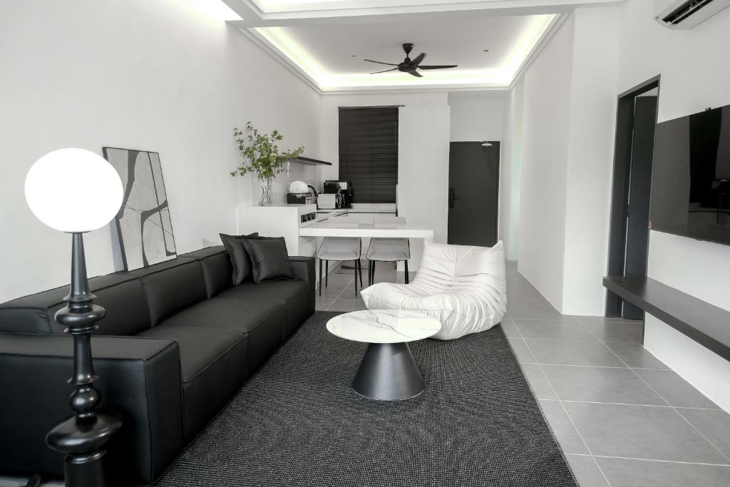 瓜埠Langkawi Homestay at Simfoni Beliza Apartment by Chien的客厅配有黑色沙发和桌子