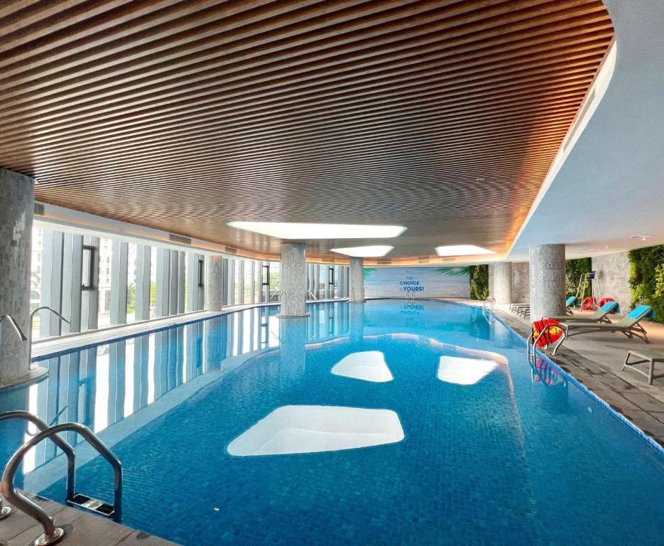 下龙湾Khách sạn A LaCarte Hạ Long - Quảng Ninh的大楼内一个蓝色的大型游泳池