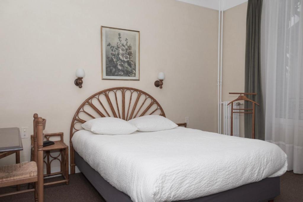 勒布朗-梅尼尔Cit'Hotel Aéro-Hotel的一间卧室配有一张带白色床单的大床