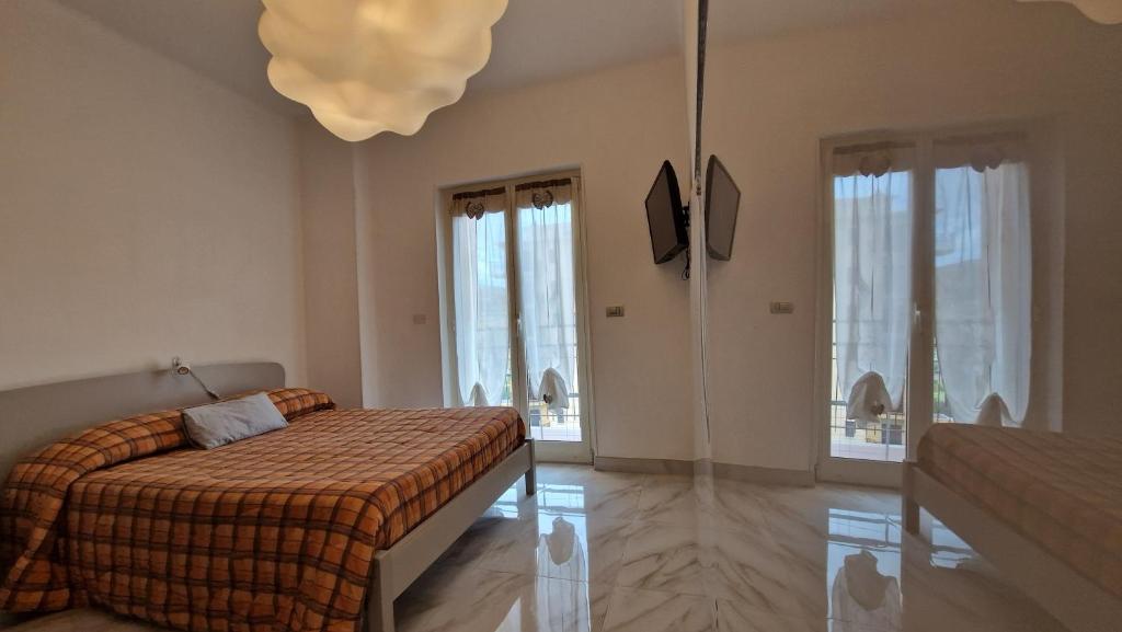 阿尔玛·迪·塔吉亚Olimpia的一间卧室配有一张床和一个吊灯