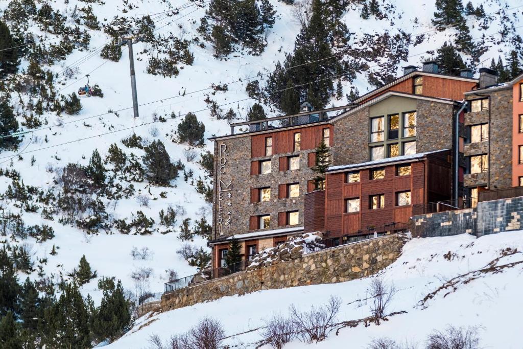 卡尼略洛克梅勒酒店的一座位于雪覆盖的山边的建筑