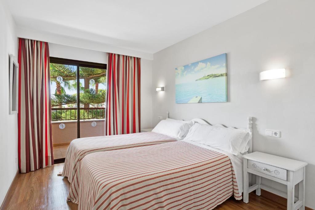 帕尔马海滩Apartamentos Pabisa Orlando的白色的卧室设有床和窗户