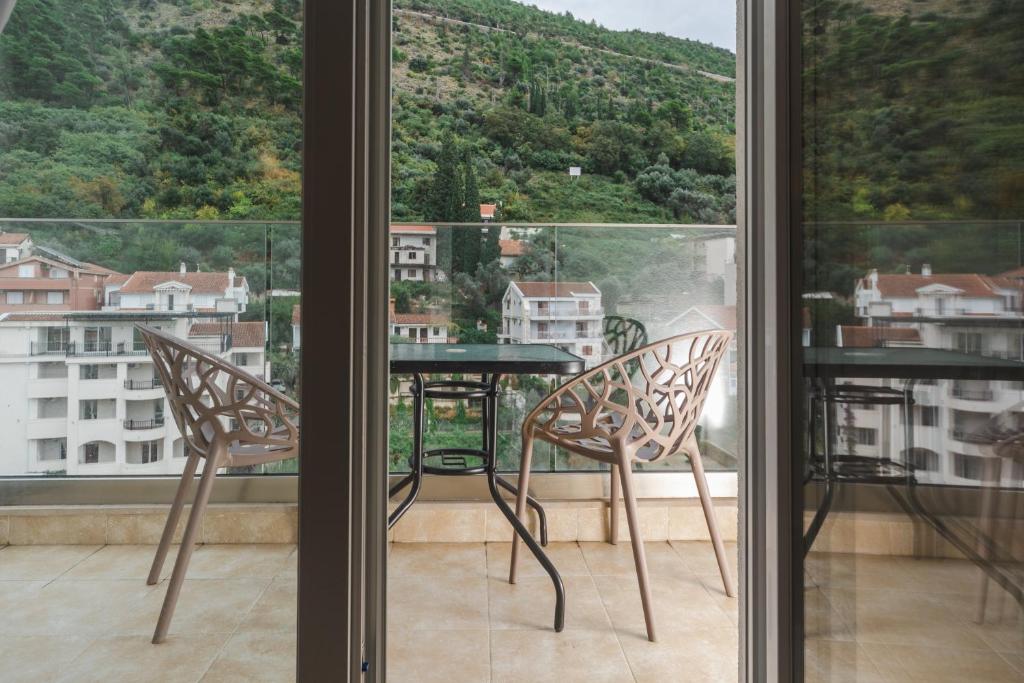 布德瓦Hotel 219 Budva的窗户前的阳台配有桌椅