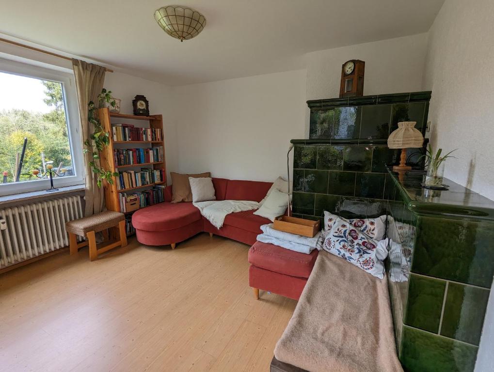 蒂蒂湖-新城Ferienwohnung Am Seebach, 80 Qm的客厅设有红色的沙发和壁炉