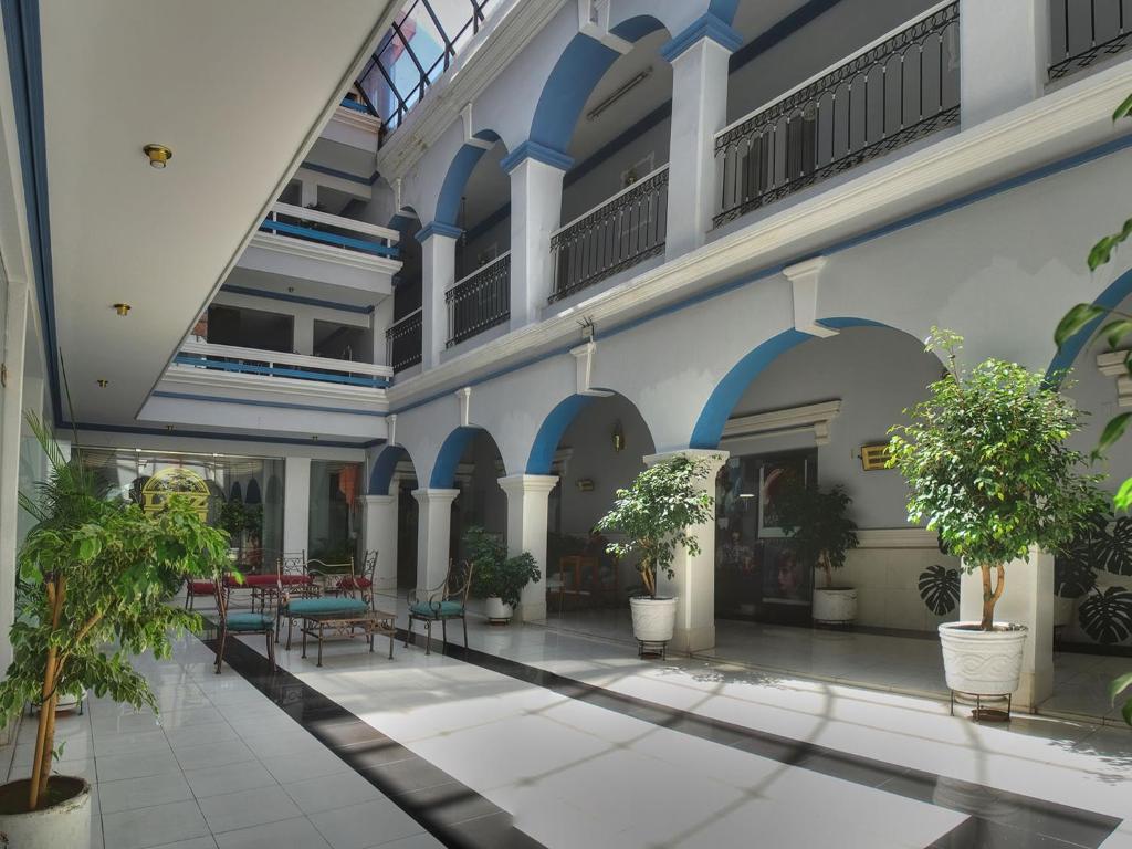 塔里哈Luz Palace Hotel的中庭,有桌子和盆栽植物的建筑