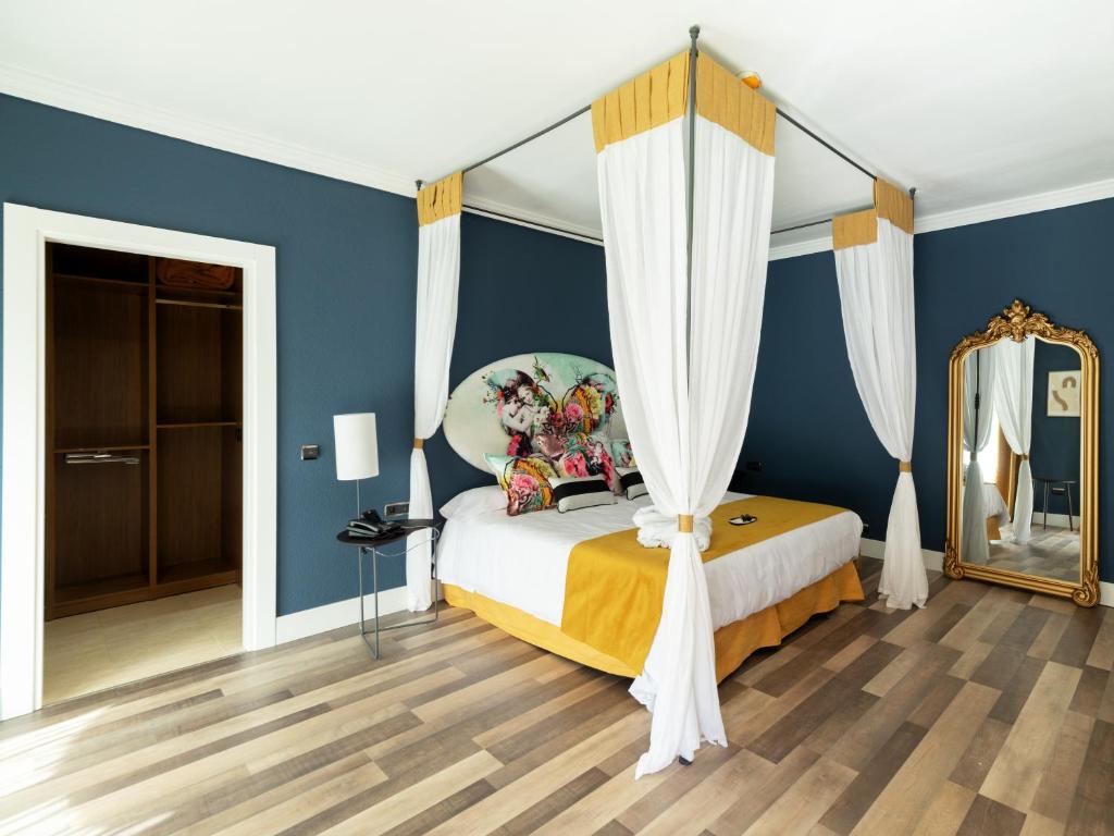 伊斯坦Hotel Altos de Istán的一间拥有蓝色墙壁的卧室和一张带镜子的床