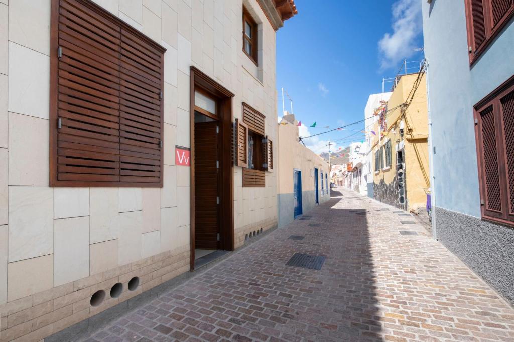 戈梅拉岛圣塞瓦斯蒂安Hauzify I Apartamento Celeste的一条狭窄的小巷,有蓝色和白色的建筑