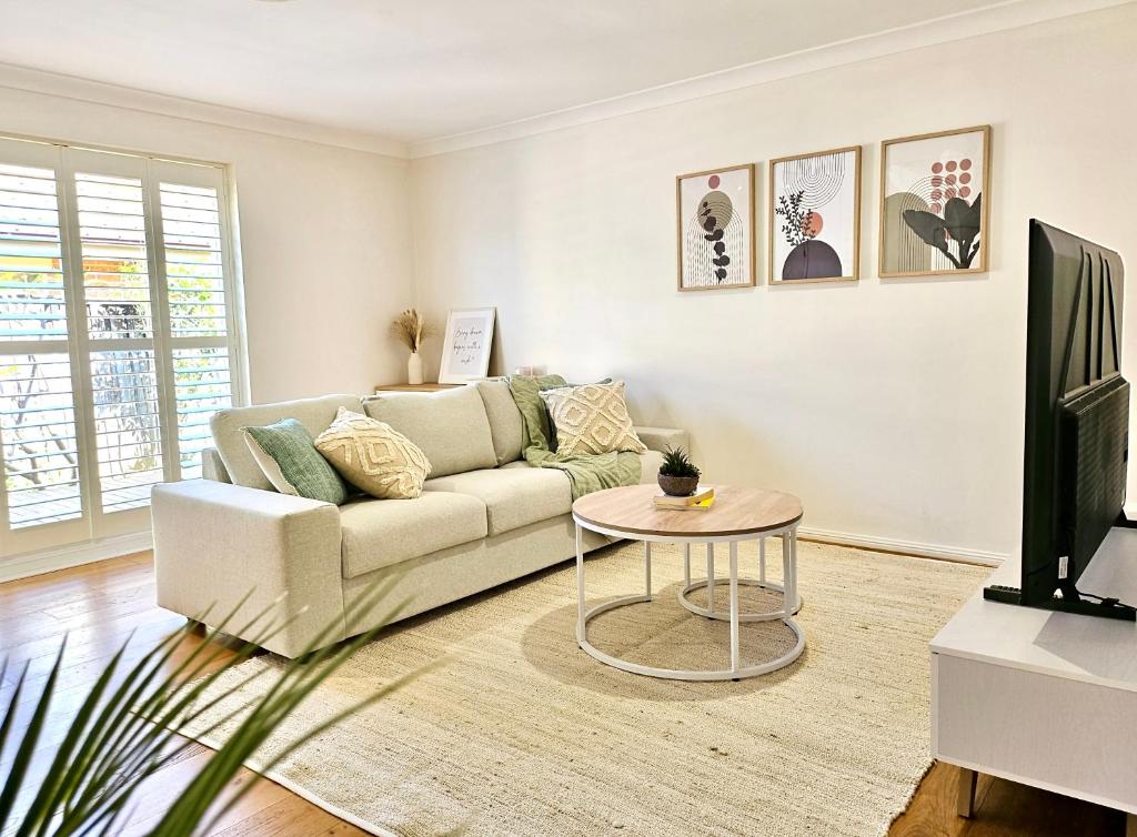 悉尼Cosy 3BR House, 7 mins drive to Macquarie Centre, 5 stars on AirB&B的客厅配有沙发和桌子