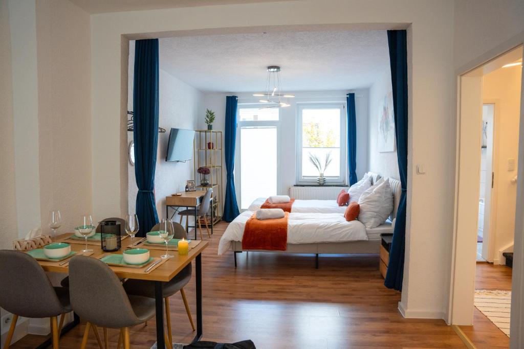 不莱梅Volante Apartment Bremen-Findorff的一间卧室配有一张床和一张桌子及椅子