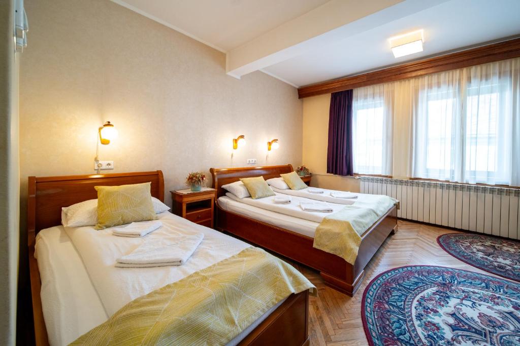 奥多尔黑塞库耶斯克Lilla Panzió的酒店客房设有两张床和窗户。