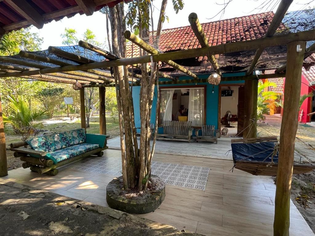 哥隆巴奥Chalé Paraíso Corumbau - Chalés Uvas Azul的一个带沙发和树的有盖庭院