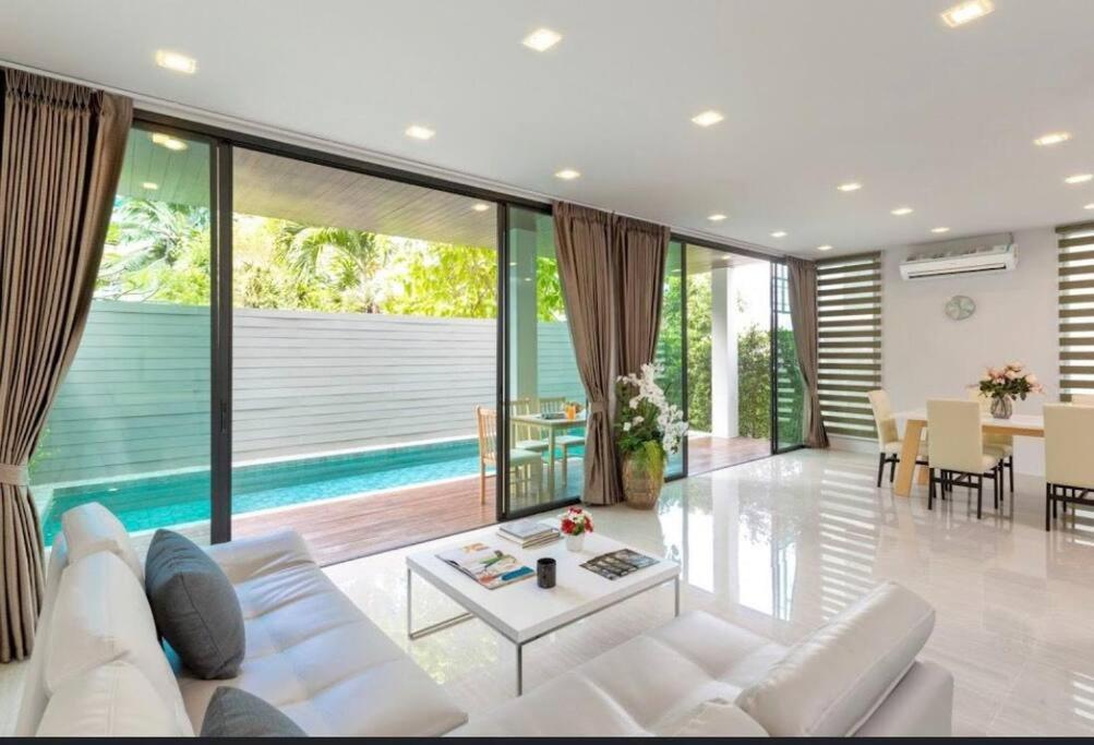 卡塔海滩4 beds 5baths Pool Villa at Kata beach的客厅配有白色的沙发和桌子