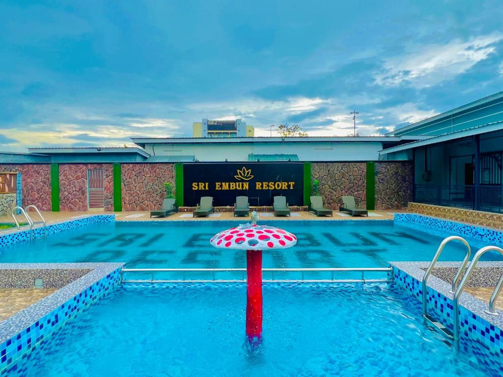 珍南海滩Sri Embun Resort Langkawi的酒店前方的游泳池配有遮阳伞