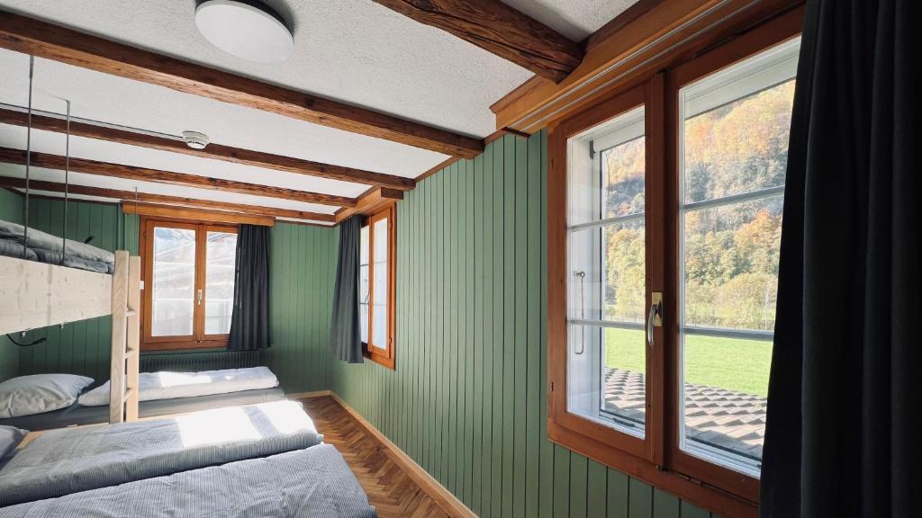 沃尔芬希森Alpina Einhorn - Self-Check-In的一间卧室设有绿色的墙壁和大窗户
