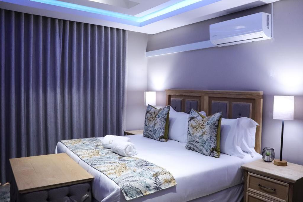 科克斯塔德EDEN BOUTIQUE HOTEL的卧室配有一张带白色床单和枕头的大床。