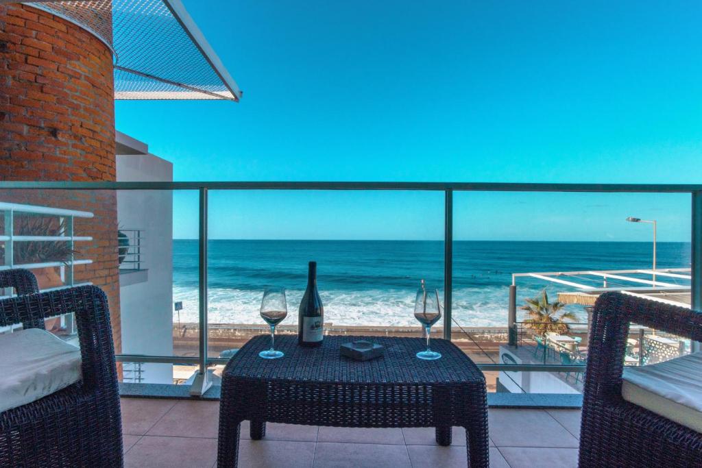 滨海保尔Apartment 7 on Paul do Mar Beach的阳台上的桌子和酒杯